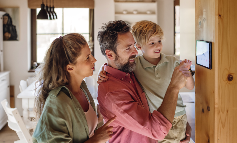 Family adjusting a smart thermometer for heating. Deschutes Climate Bend Oregon HVAC